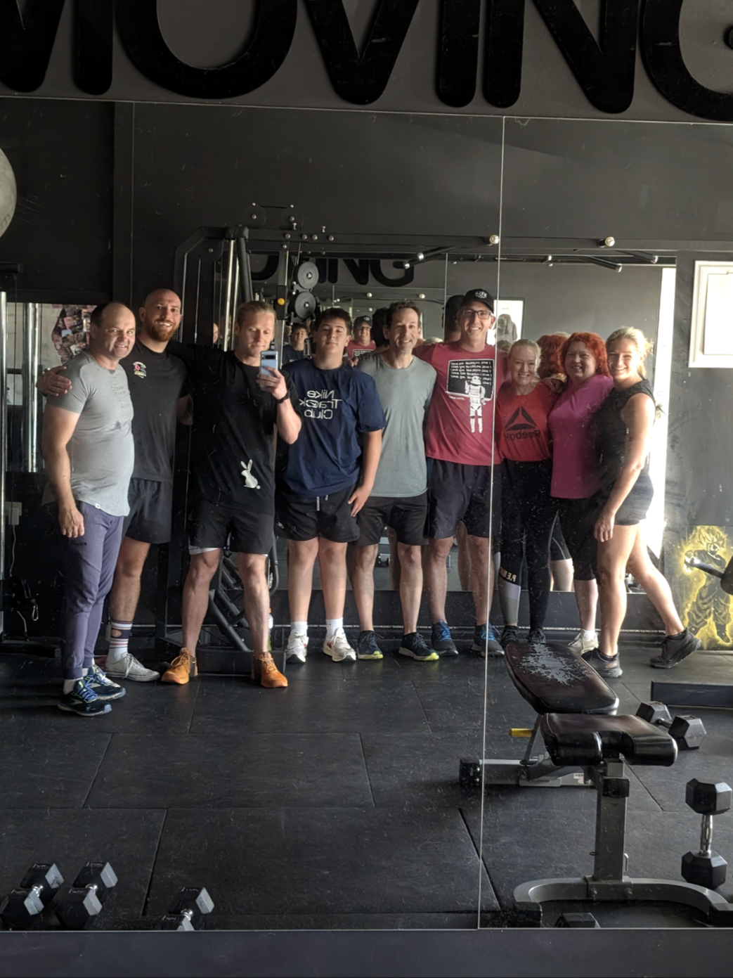 Shannon standing with a group of training partners inside his gym